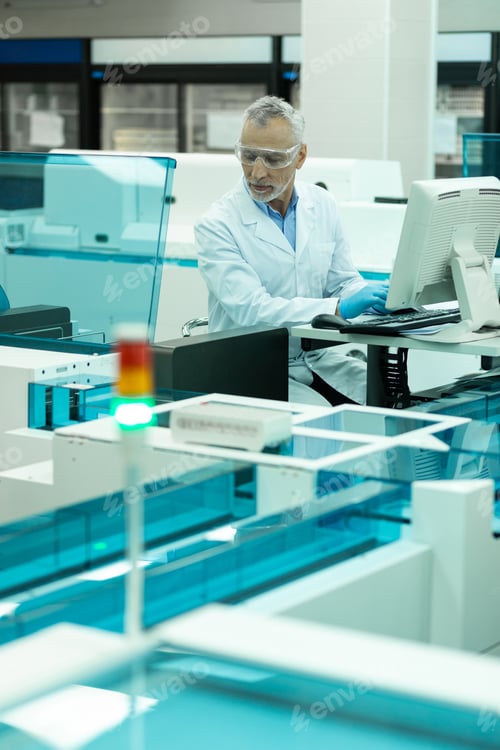 Preview: Pleased mature man testing computer in lab