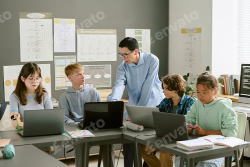 Preview: Teacher Instructing Diverse Teenagers Using Laptops in Classroom