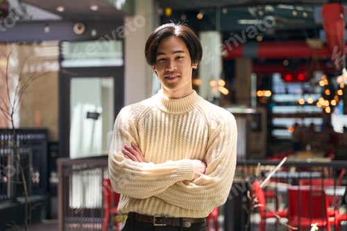 Preview: Handsome smiling Japanese man wearing stylish sweater holding arms crossed looking at camera