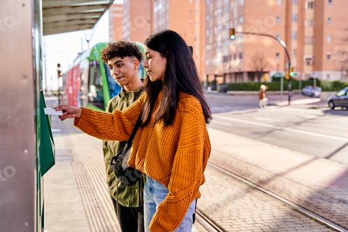 Preview: teenage couple buying tram tickets with their credit cards