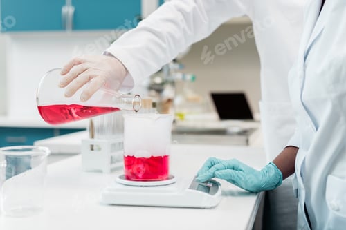 Preview: Close-up partial view of scientists making experiment with reagent and flasks