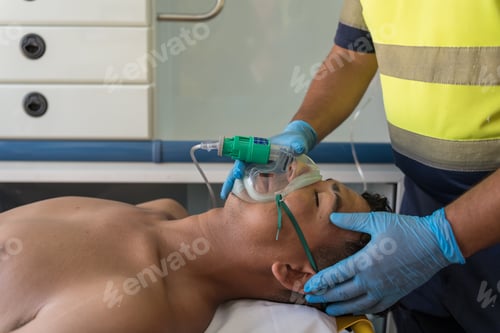 Preview: Paramedic putting oxygen mask on patient lying in ambulance