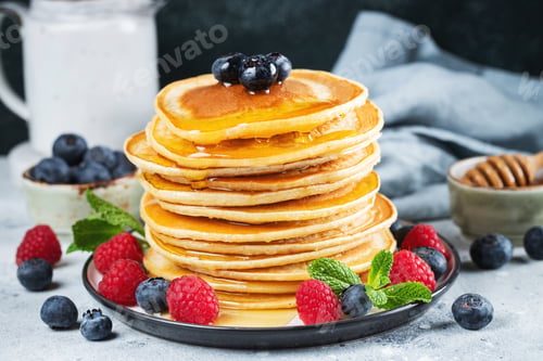 Preview: Delicious pancakes, with fresh blueberries, raspberry and maple syrup or honey on a dark background