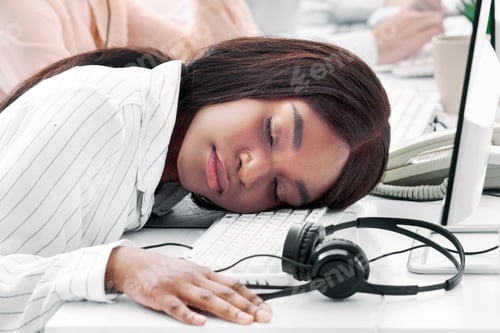 Preview: Tired hotline consultant sleeping at her desk, feeling exhausted or stressed after communication