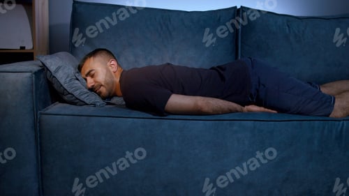 Preview: Exhausted overloaded young man in casual clothes came home after work flopped down on sofa very