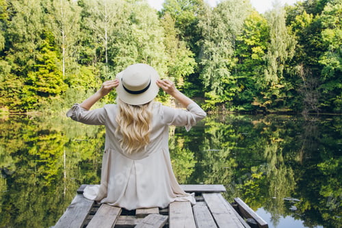 Preview: Beautiful Young Blonde Girl In A Hat Resting On The Autumn Lake On The Bridge. Toning.