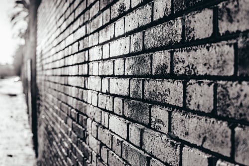 Preview: Brick wall background at sunset with sun rays, stone texture.