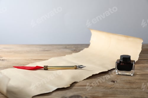 Preview: Old paper scroll, inkwell and fountain pen on wooden table, closeup