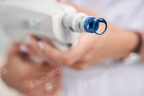 Preview: Female beautician using laser in cosmetological office