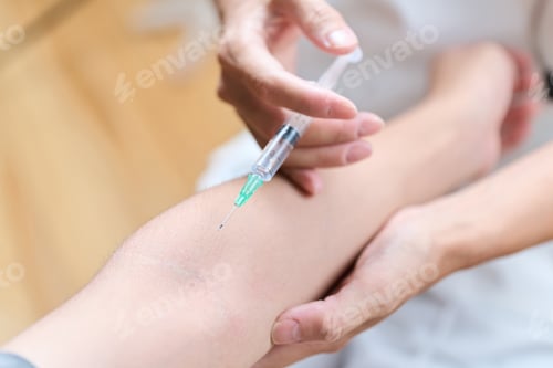 Preview: Asian doctor making an injection in his arm