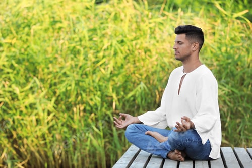 Preview: Man meditating on wooden pier outdoors. Space for text