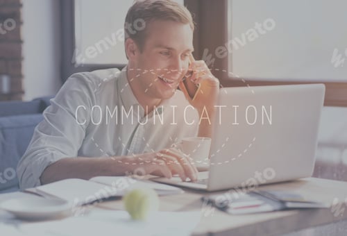 Man Working At Laptop Talking On Phone