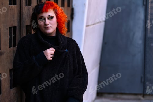 Preview: Transgender girl with orange painted hair looking at camera.