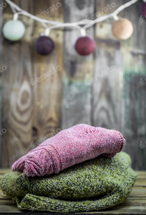 Preview: Cozy Knitted Garments Stacked Before Wood Paneling
