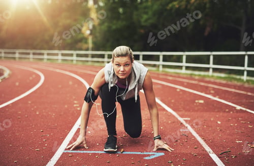 Preview: Woman on track field in crouch start position