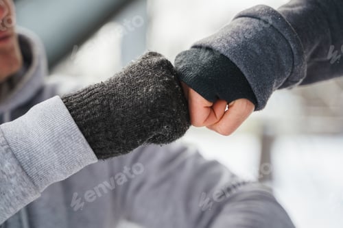 Preview: Fist bump gesture between two friends during winter workout