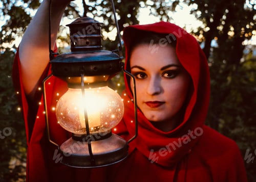 Preview: Beautiful woman wearing red cape in woods, fairytale, storybook. Red Riding Hood. Fantasy. Fireflies