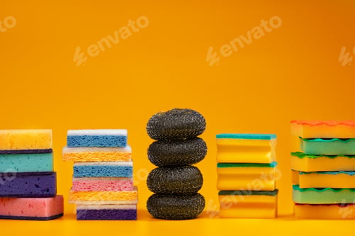 Preview: Stacked household cleaning sponges on yellow background