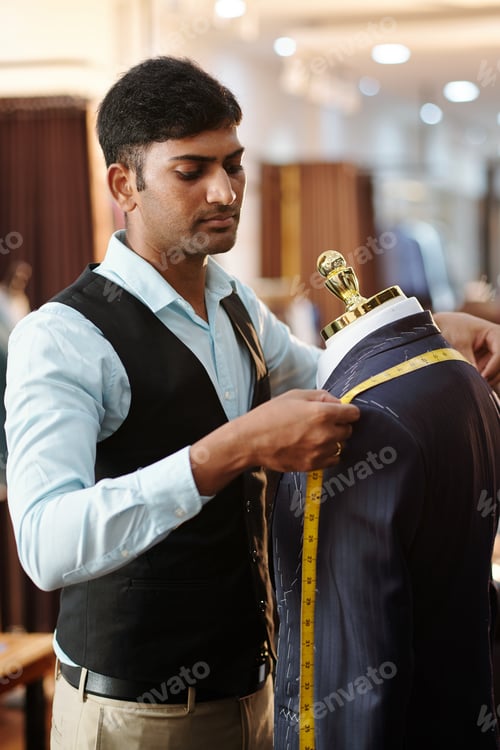 Preview: Tailor Measuring a Suit on Mannequin in Store