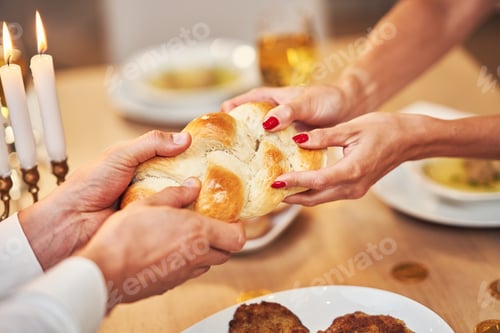 Preview: Hanukkah dinner. Family gathered around the table sharing challah