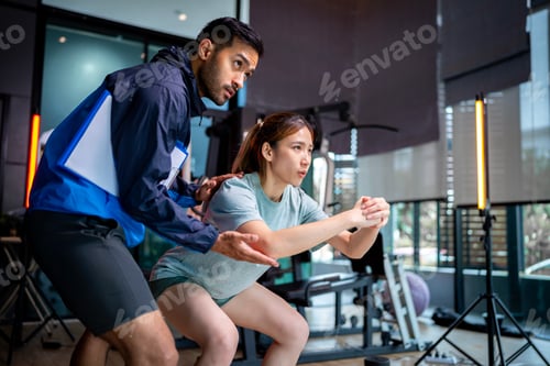 Preview: Woman Exercising With Trainer in a Gym