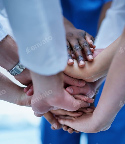 Preview: Cropped shot of a team of doctors joining their hands in solidarity