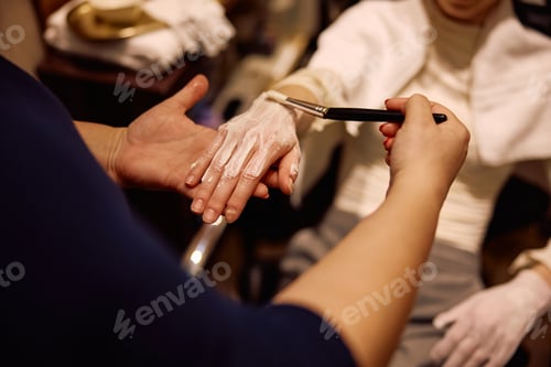 Preview: Close up of woman getting moisturizing skin care treatment at health spa.