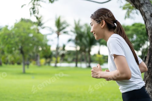 Preview: Asian young beautiful sport woman running on street in public park.