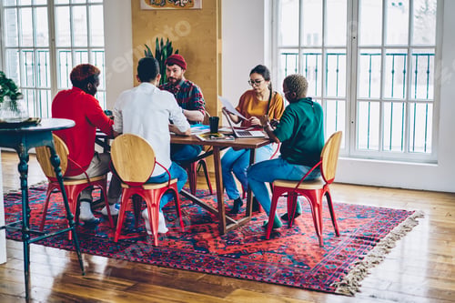 Preview: diverse people teamworking during briefing at desktop with laptop
