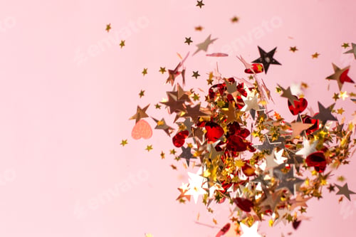 Preview: Silver, red and gold star confetti on pastel pink background. Bright and festive holiday background.