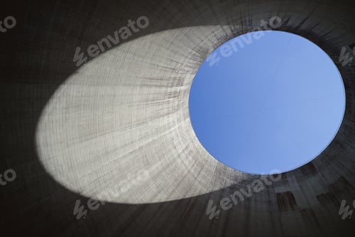 Preview: Low angle shot from inside of a cooling tower with a blue sky in the background