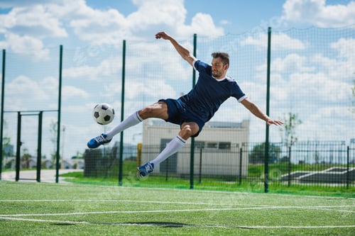 Preview: athletic soccer player kicking ball on soccer pitch