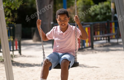 Preview: Young boy swinging on playground enjoying childhood fun