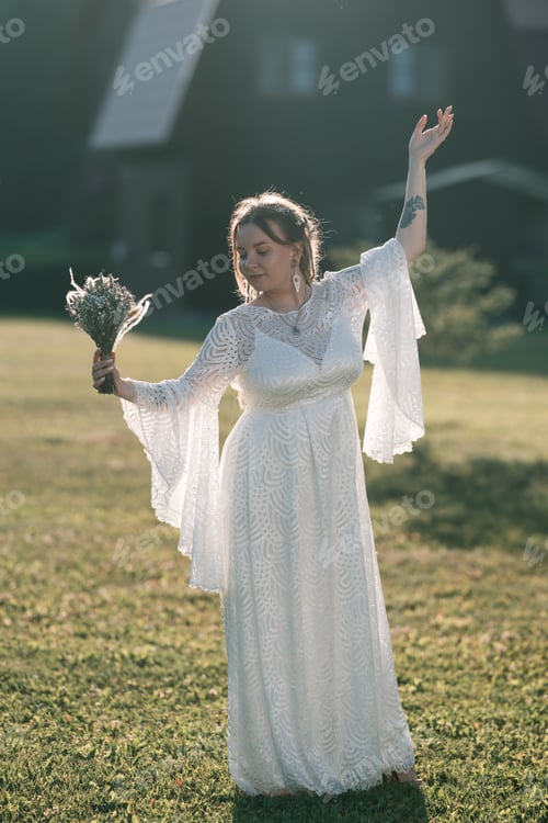 Preview: Bride in white dress with bouquet dancing.
