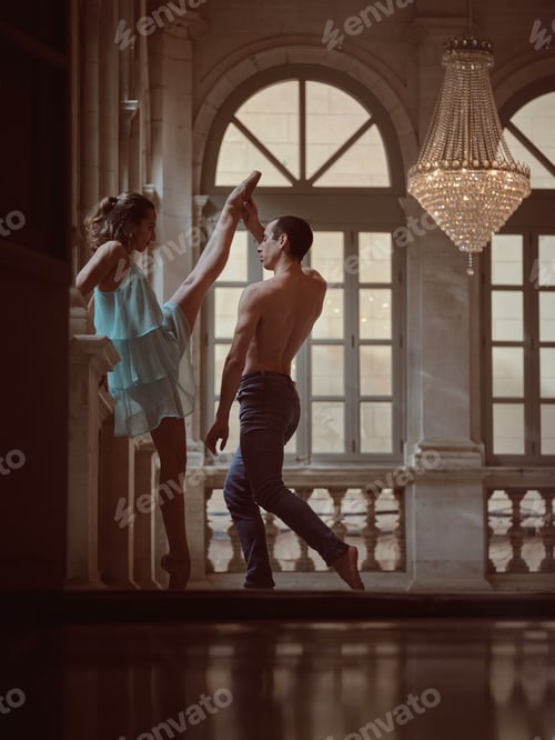 Preview: Ballet dancer raising leg of female partner in hall