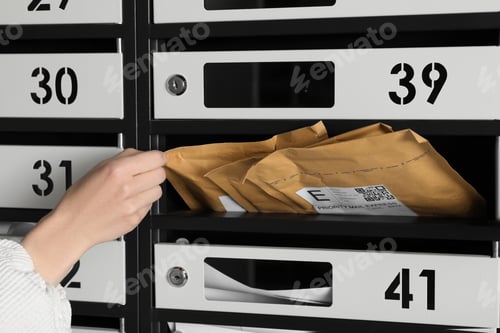 Preview: Woman taking envelope out of mailbox, closeup