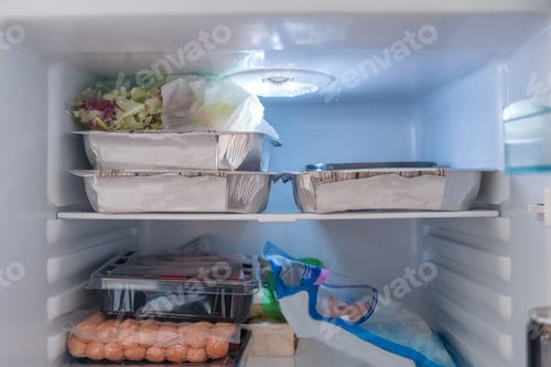 Preview: Open refrigerator filled with raw food, vegetables and foil package