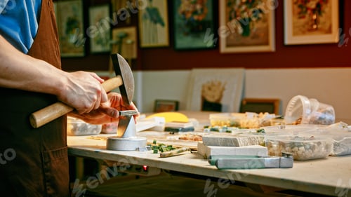 Preview: Young man with a hammer at work in studio close-up. Working man with a hammer
