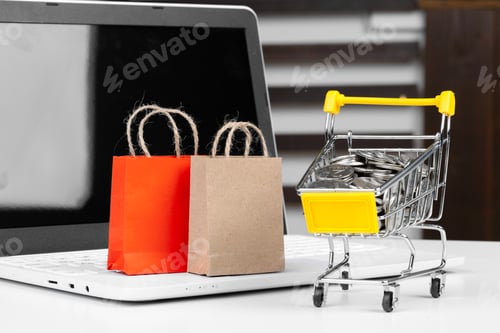 Preview: Online shopping concept. Shopping cart, laptop on the desk