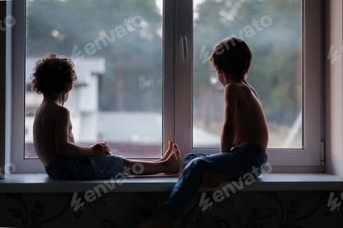Preview: Two real brothers sitting at the window and looking throw it to the street