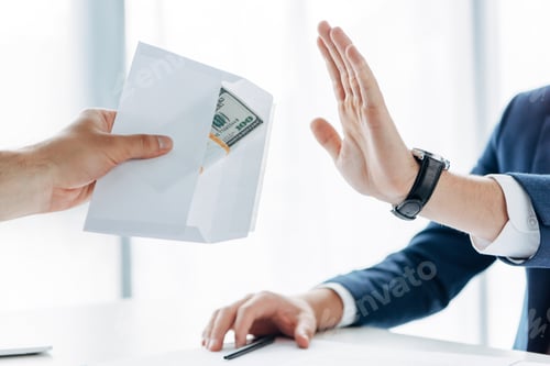Preview: cropped view of man gesturing near business partner giving envelope with money in office