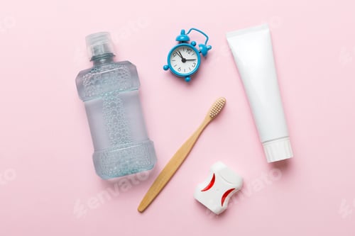 Preview: Mouthwash and other oral hygiene products on colored table top view with copy space