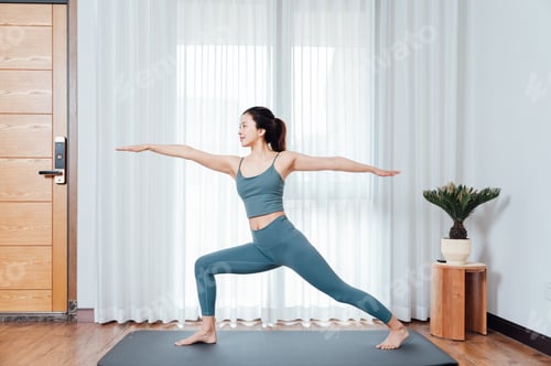 Preview: Young Asian woman doing yoga indoors