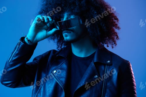 Preview: Portrait of fashion man with curly hair with stylish glasses on blue background multinational