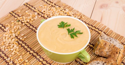 Preview: Pea soup in a green bowl with parsley.