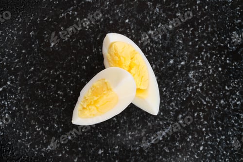 Preview: Overhead view of half of boiled egg cut on two pieces