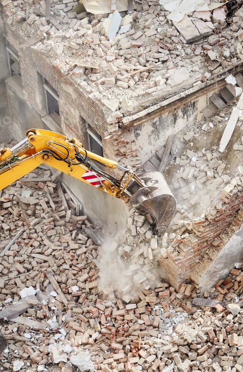 Preview: Excavator bucket in dust cloud during building demolition.