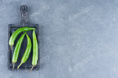 Preview: Green chili peppers on wooden board