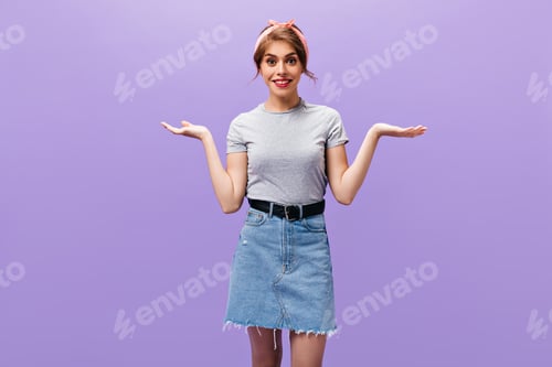 Preview: Dark haired woman in denim outfits shrugging. Charming pretty girl with pink lips in grey t-shirt p