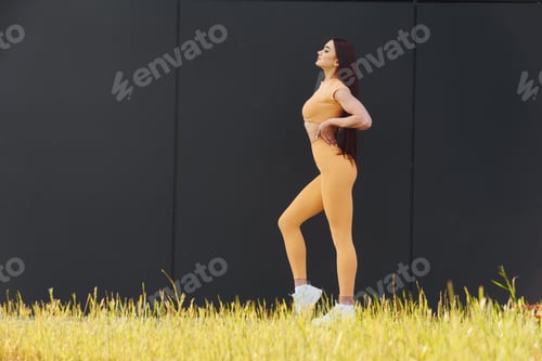 Preview: Green grass. Young woman in sportswear have fitness session outdoors